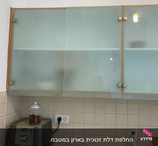 ארונות זכוכית חלבית במטבח עם ידיות מתכת
